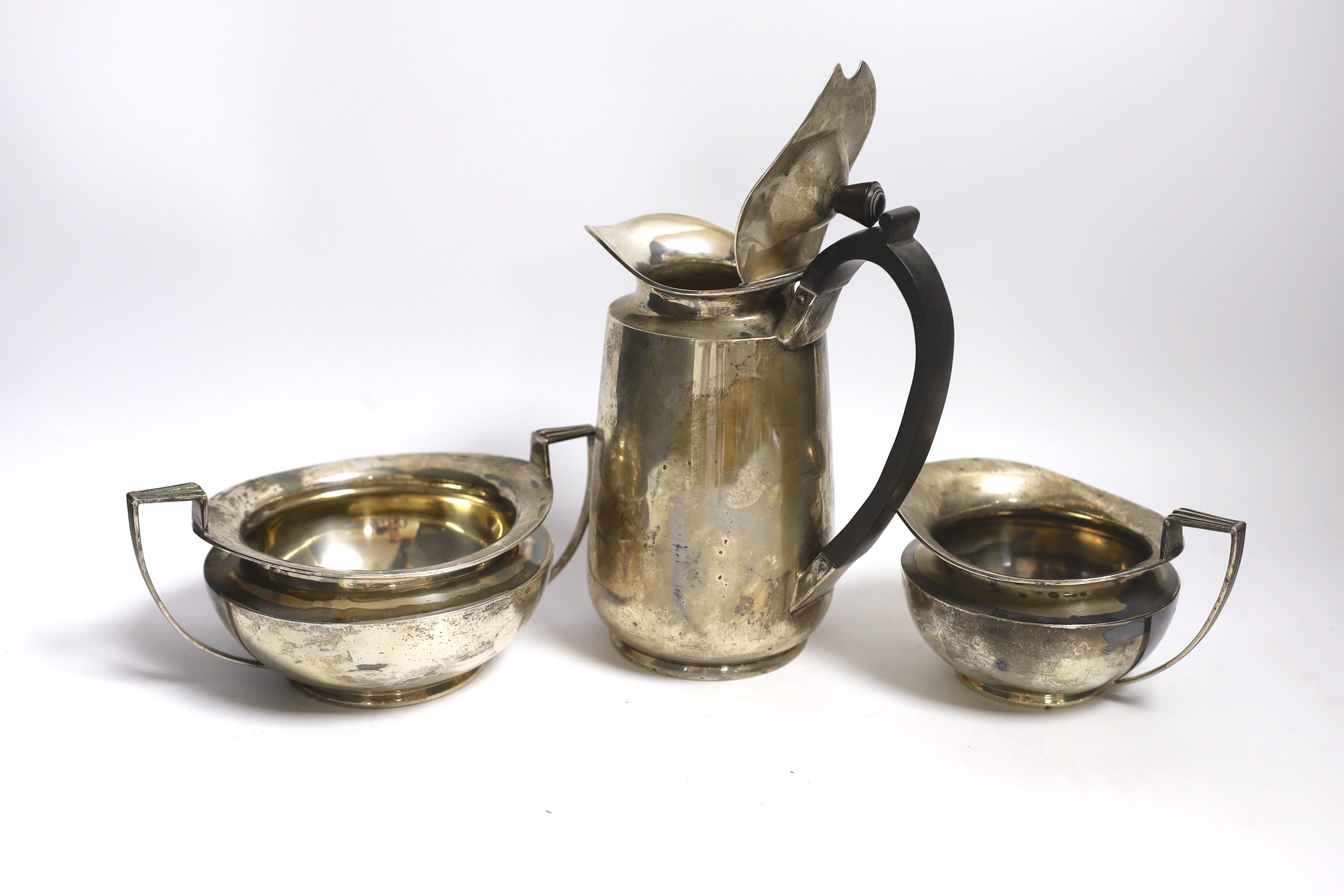 An Edwardian silver hot water pot and matching sugar bowl and cream jug, Daniel & John Welby, London, 1908/9, gross weight 45oz.